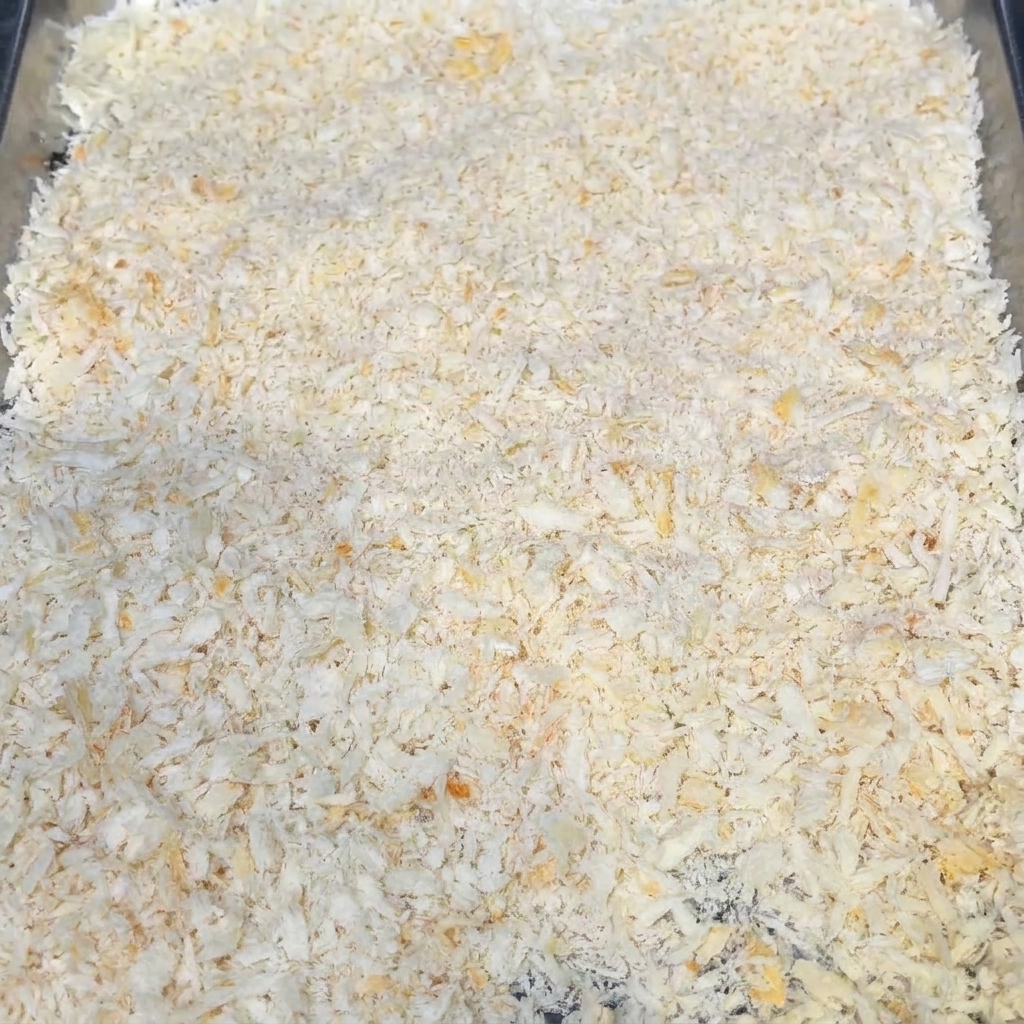 A tray filled with dry breadcrumbs, showing the surface texture.