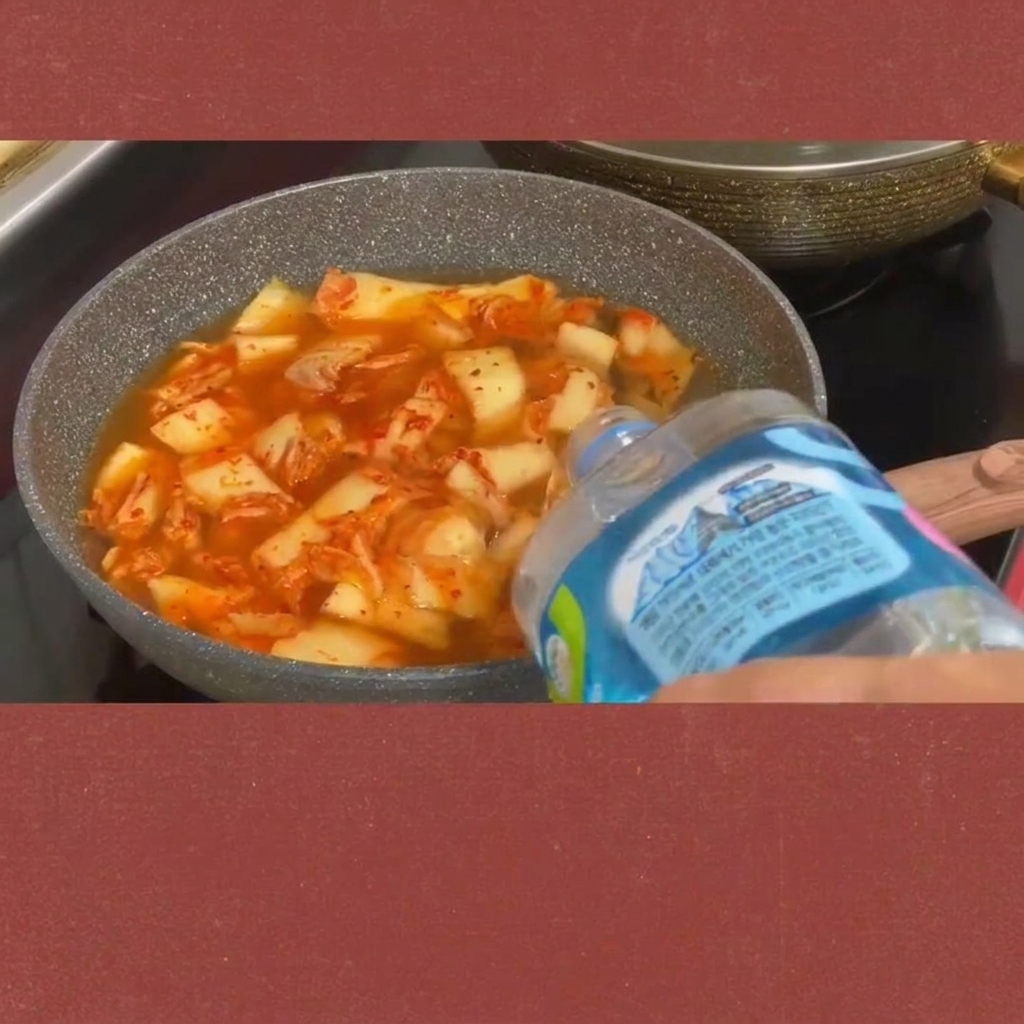 Slices of spam being added to the bubbling kimchi stew.