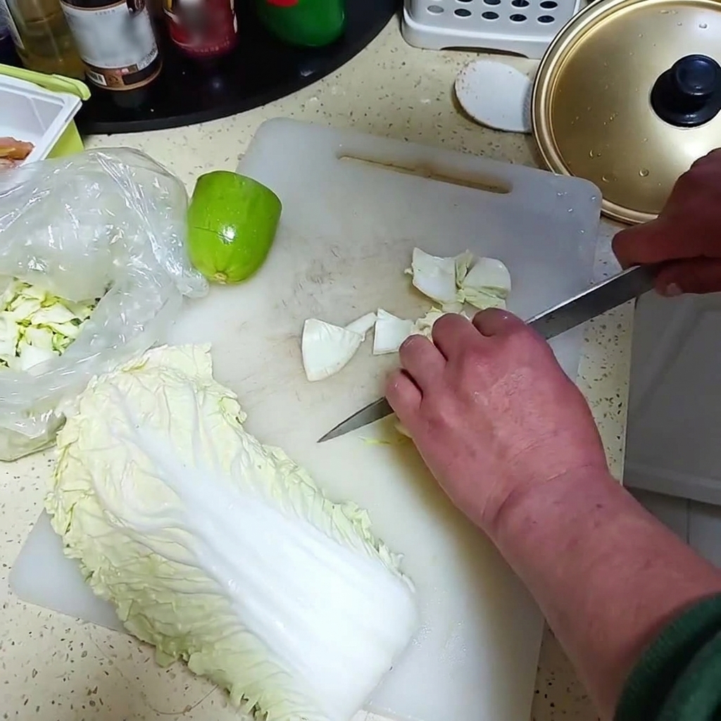 Fresh onion and a small green melon being chopped into chunks on a white cutting board.