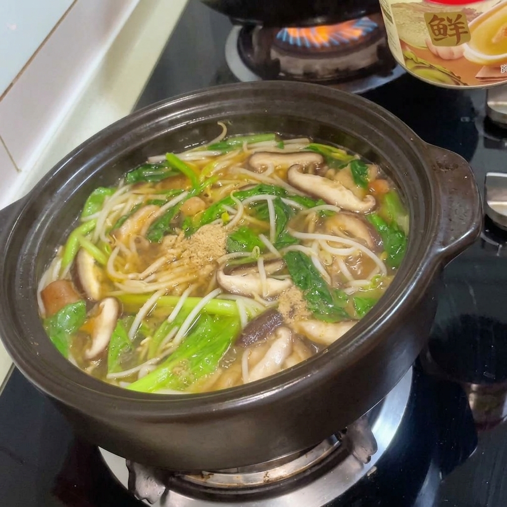 Beef seasoning powder being sprinkled into the bubbling, colorful stew in the clay pot.