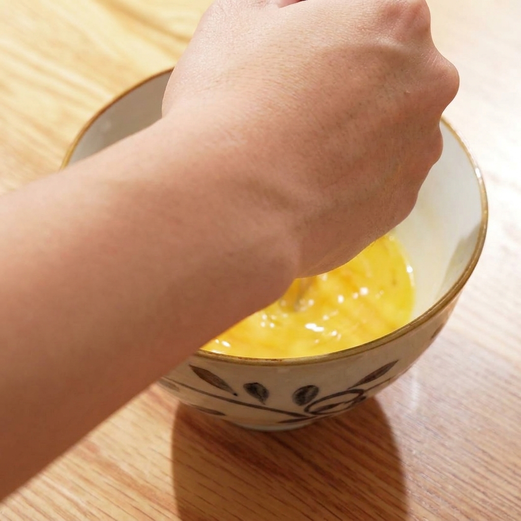 Four raw eggs cracked into a ceramic bowl ready to be beaten.