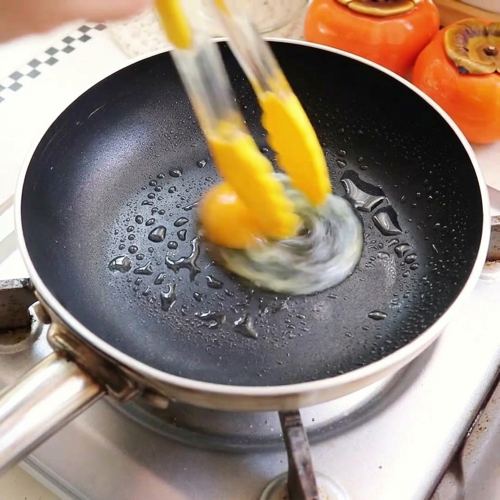 Eggs frying in a pan with hot oil.