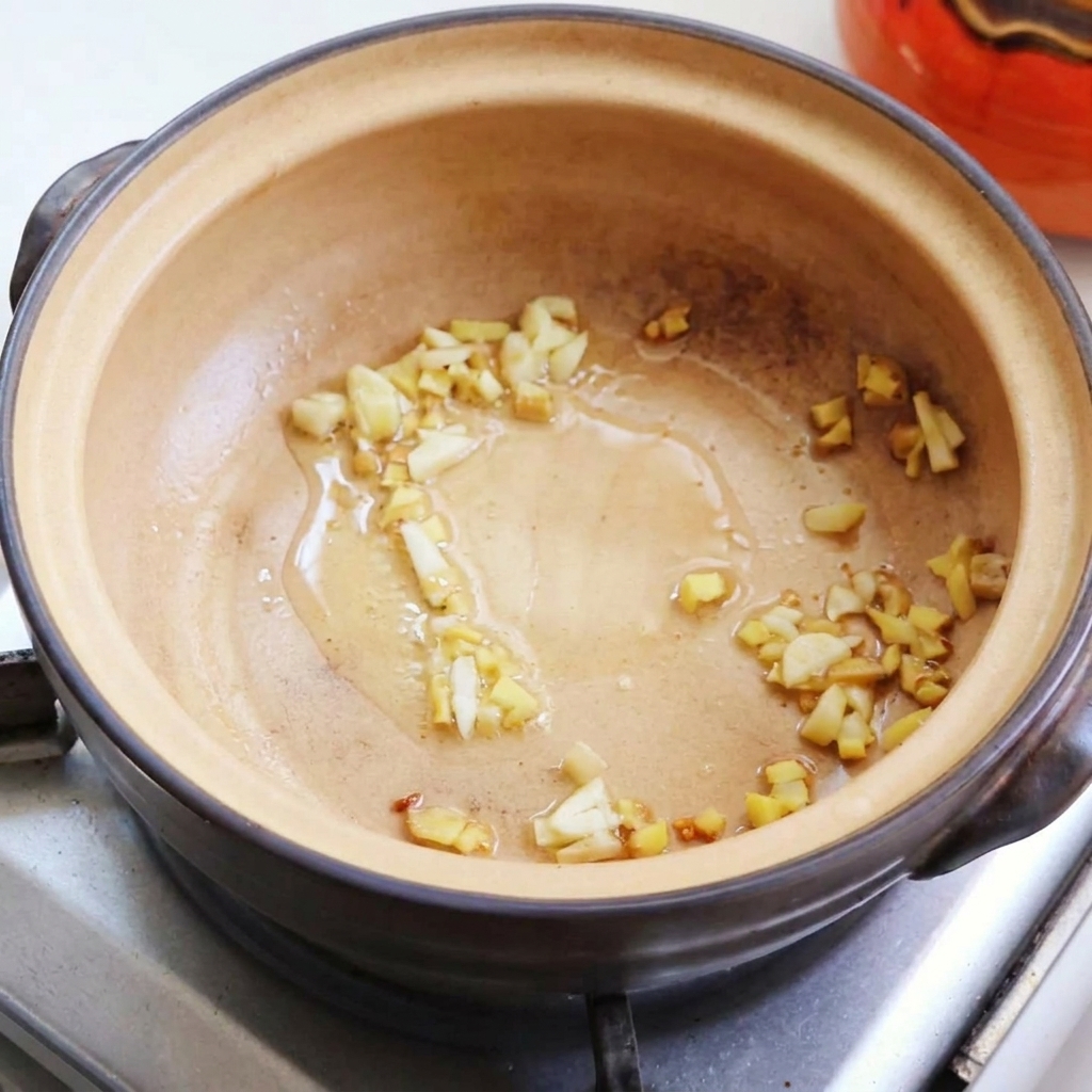 Fried egg pieces being transferred into the clay pot.