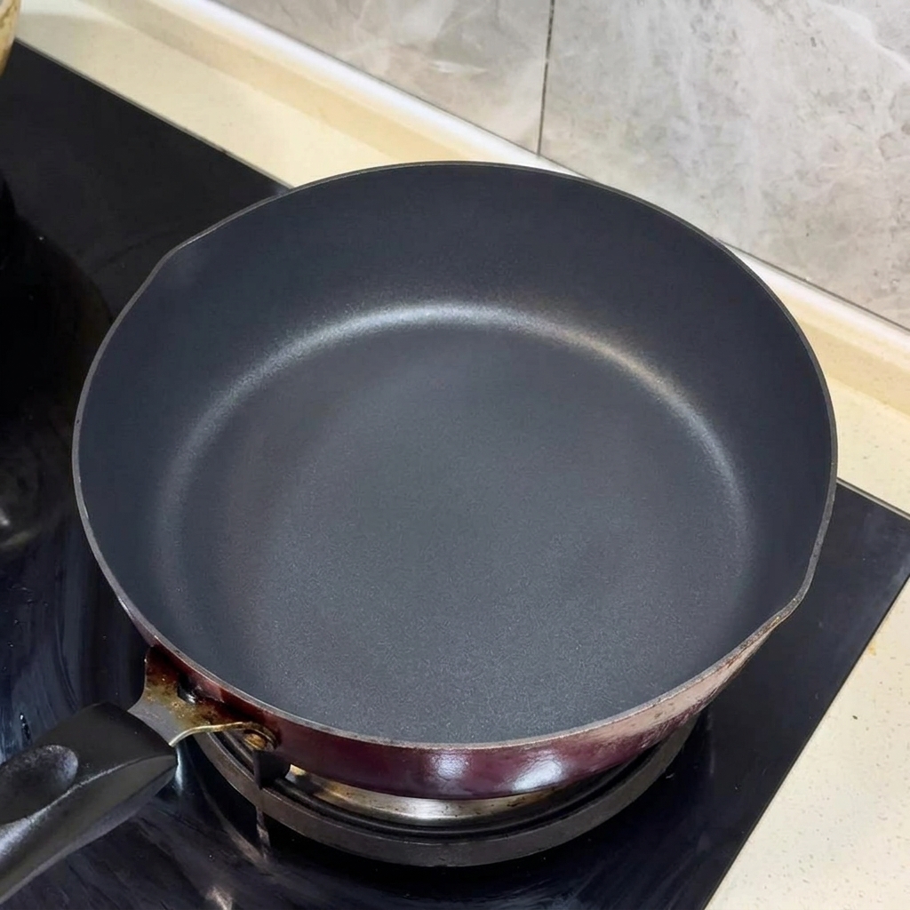 Chopped scallions and ginger strips sizzling in hot oil in a black pan.