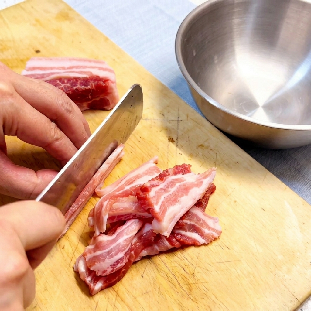 Slices of raw pork belly arranged neatly on a wooden cutting board, ready for the next step.