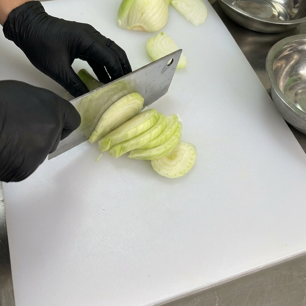 Fresh bell peppers being cleaned and deseeded on a white cutting board.