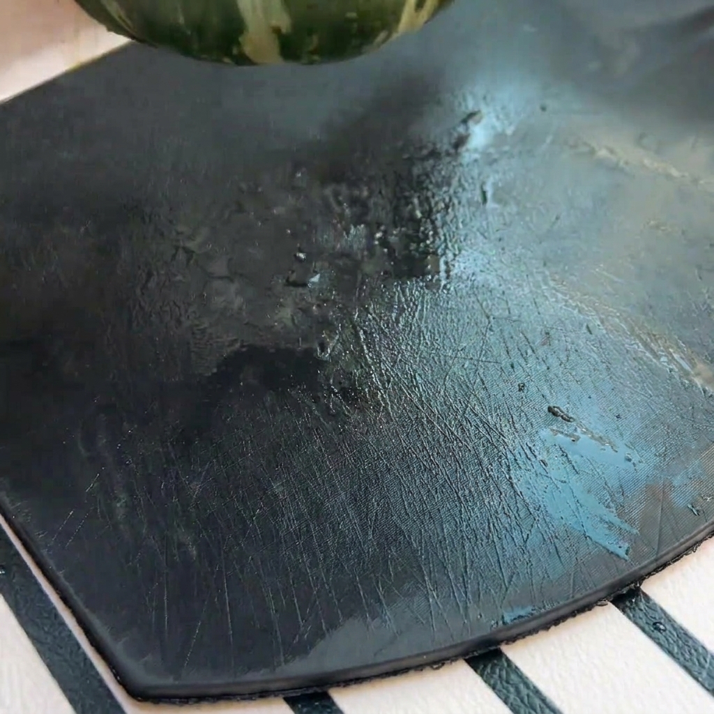 A close-up shot of a halved green pumpkin with seeds being scooped out by a spoon.