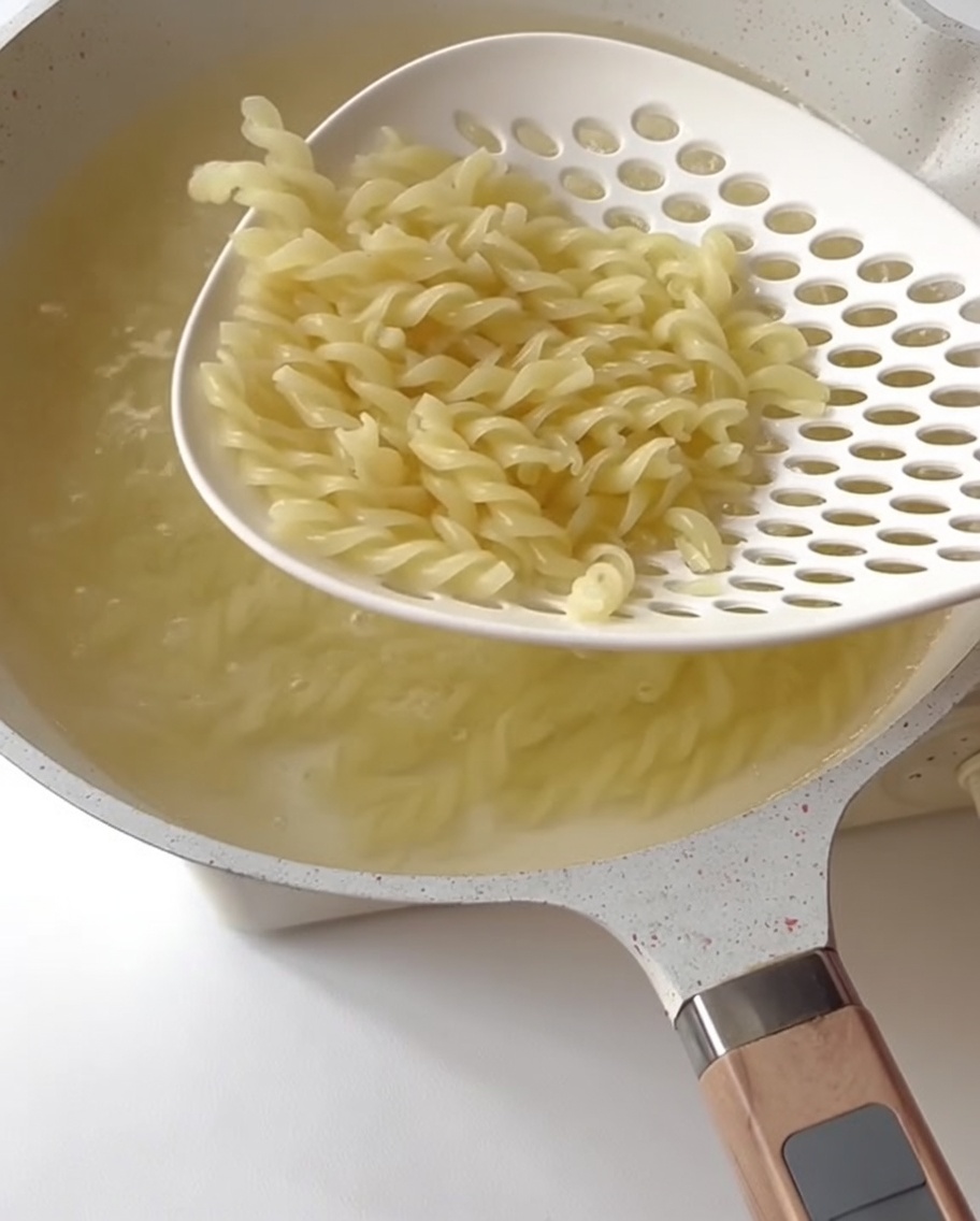 Green asparagus segments cooking in boiling water.