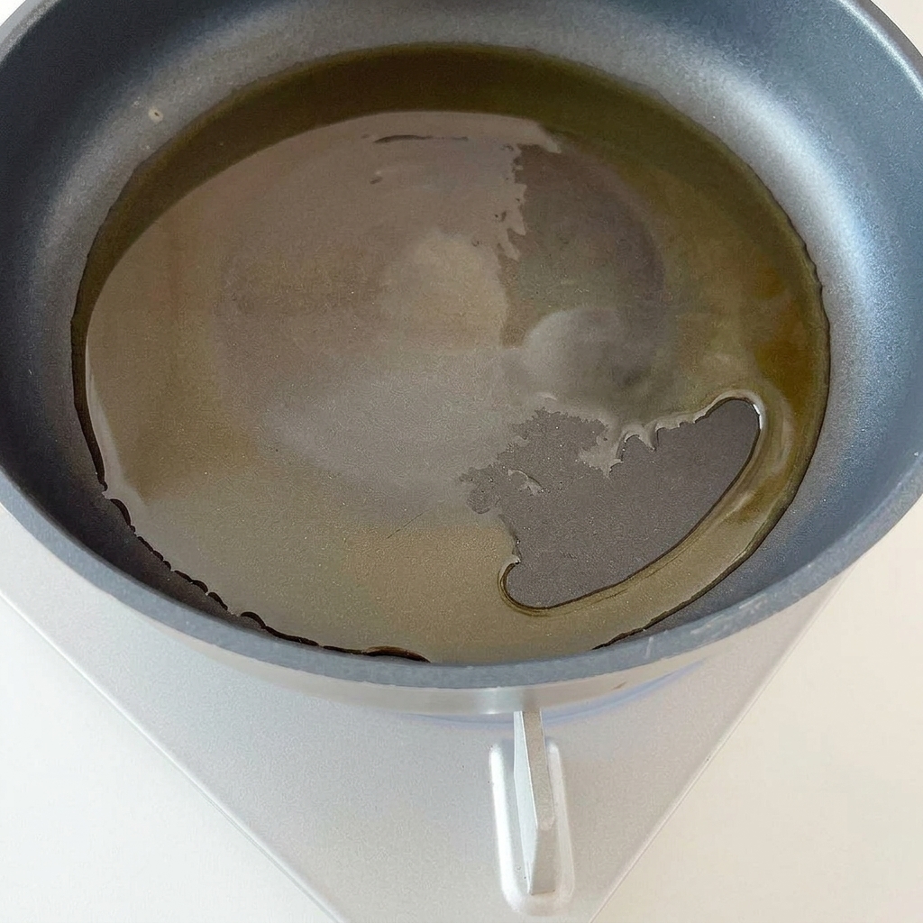 Chopped red onion cooking in a hot pan with oil.