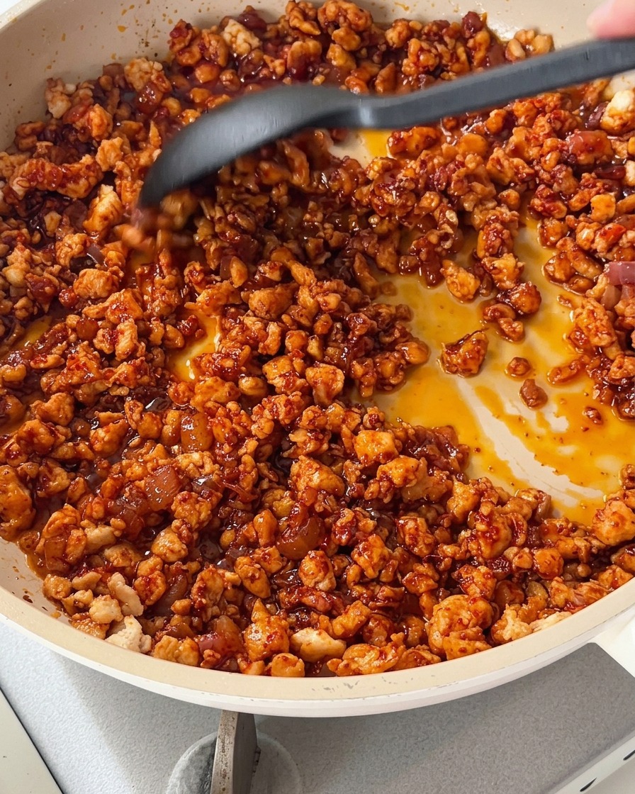 Cooking the chicken mixture with colorful diced bell peppers in a skillet.