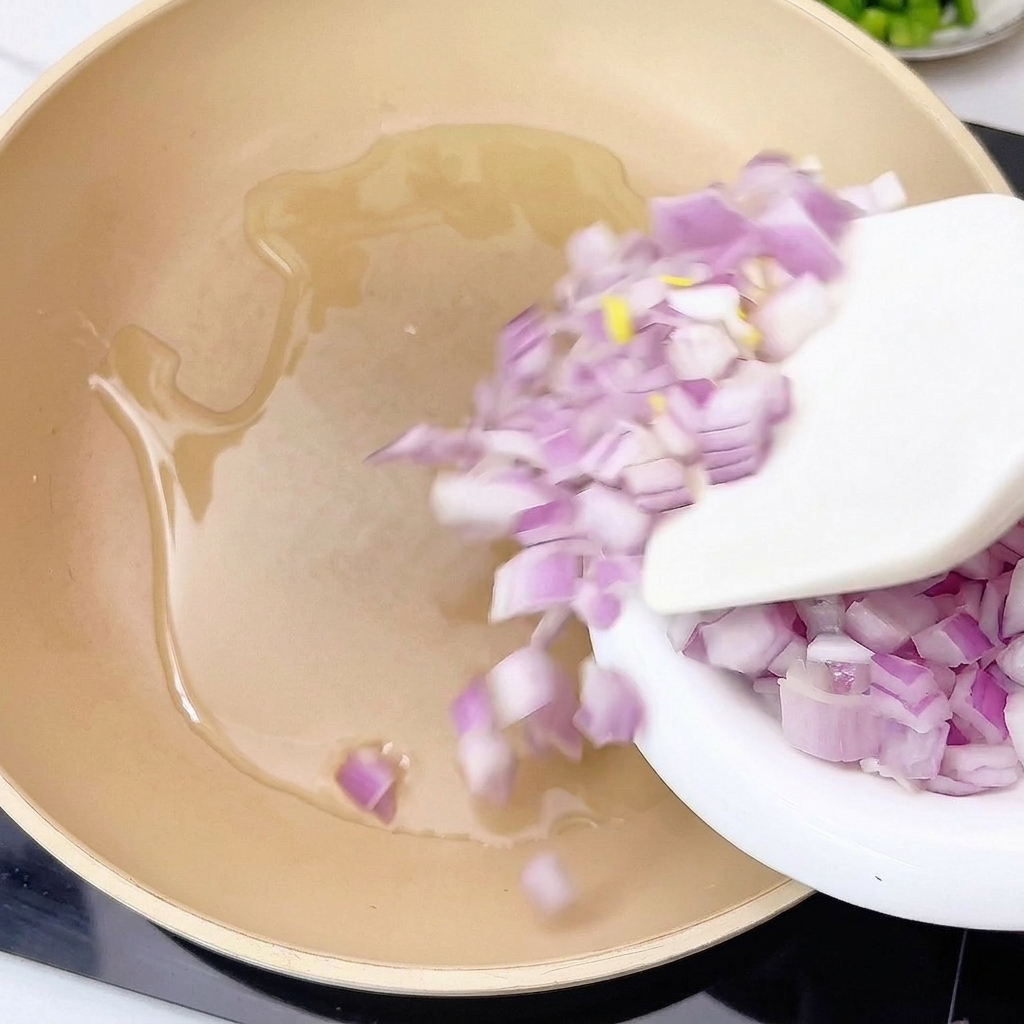 Onions and garlic being sautéed in a pan with hot oil.