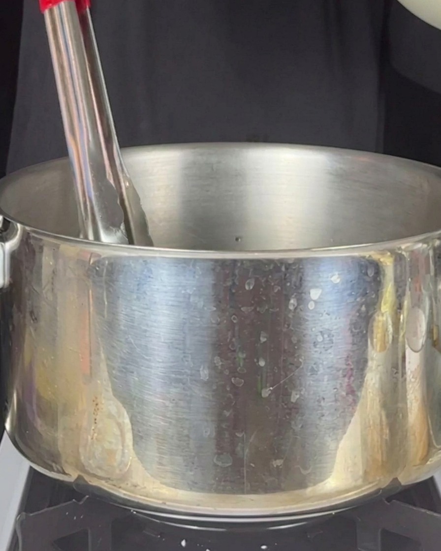 Breaded stuffed pasta tubes deep-frying in hot oil.
