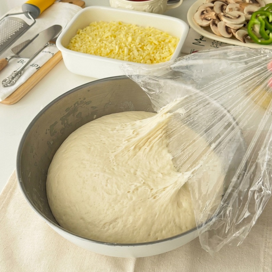 Puffy fermented dough being pulled into two portions.