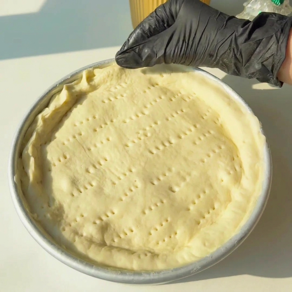 Hands pinching the dough edges to seal the top and bottom layers of the pie together.