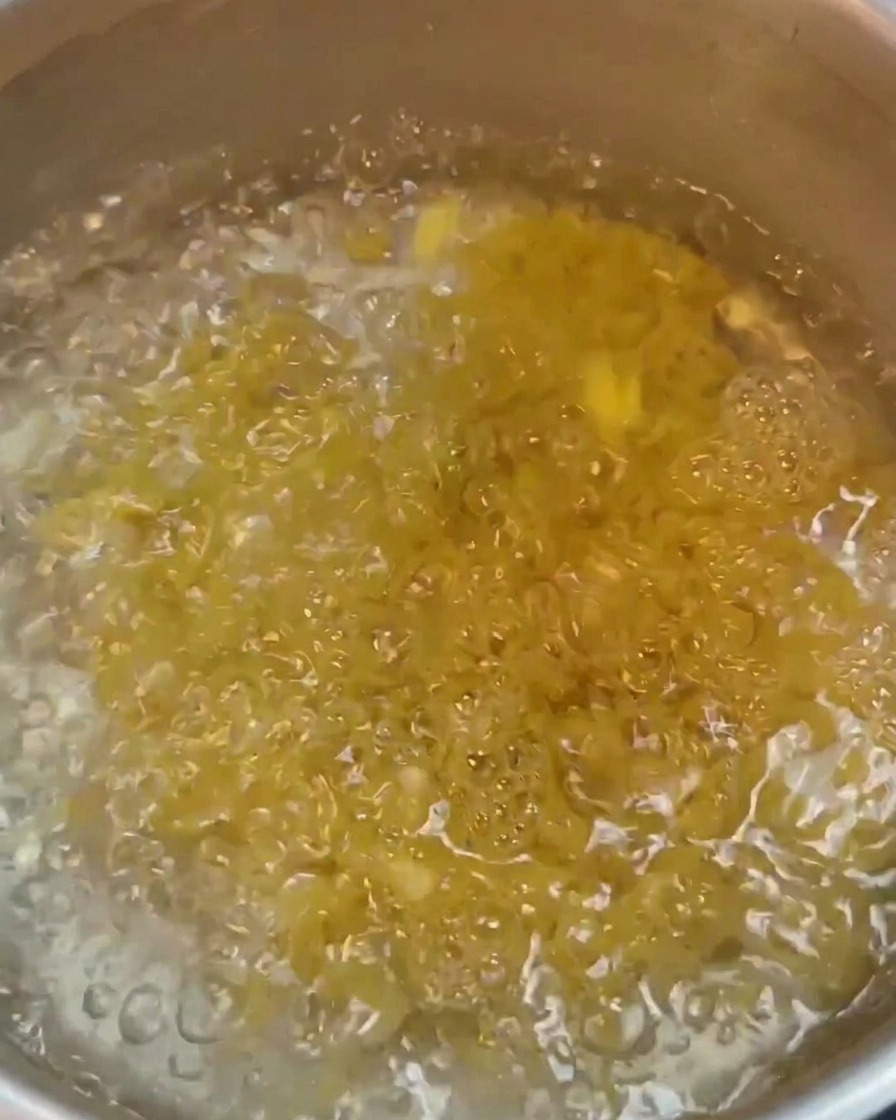 Macaroni boiling vigorously in a pot of water.