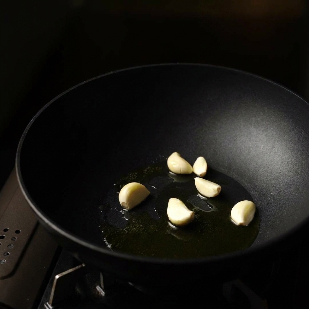 Garlic, onions, and mushrooms cooking in a pan.
