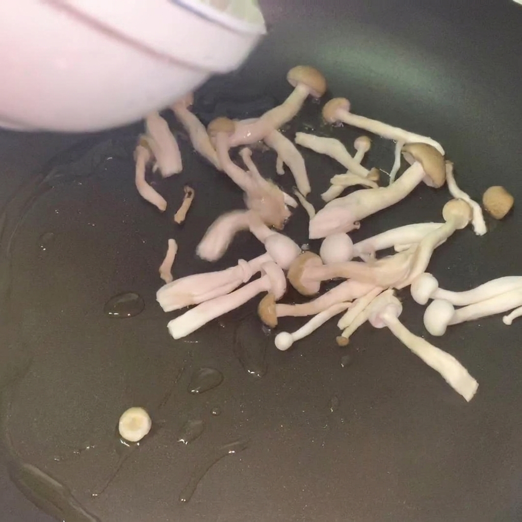 Fresh mushrooms sautéing in a pan with hot oil until golden.