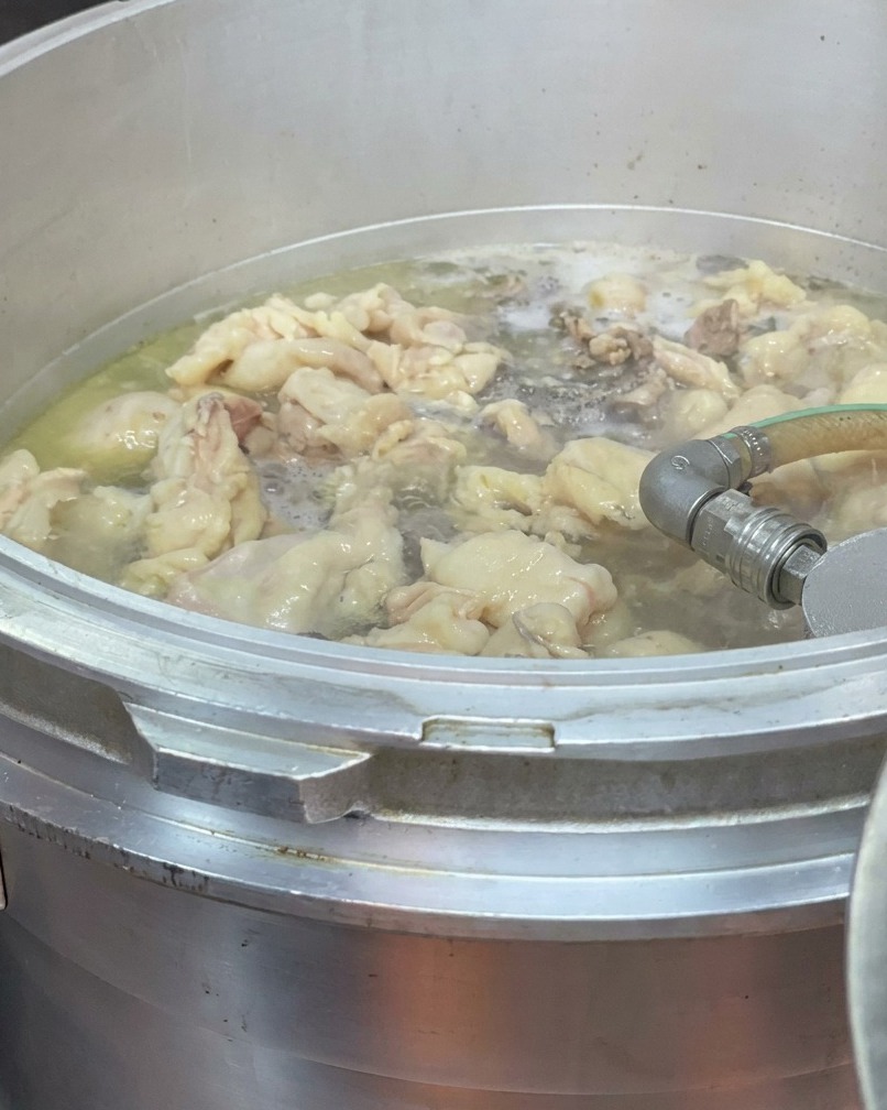 Industrial pressure cooker running with steam visible.