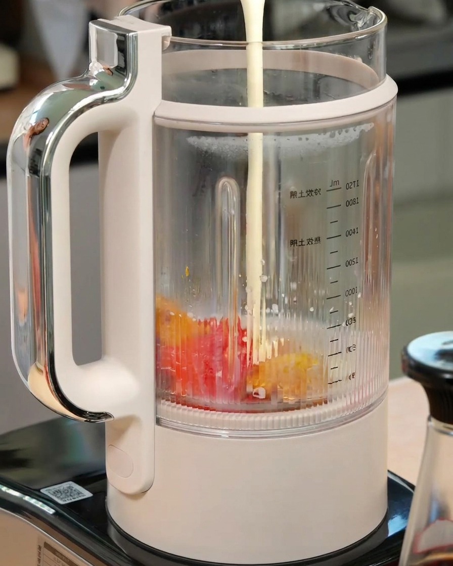 Milk and heavy cream being poured into a blender containing roasted pumpkin and bell pepper.