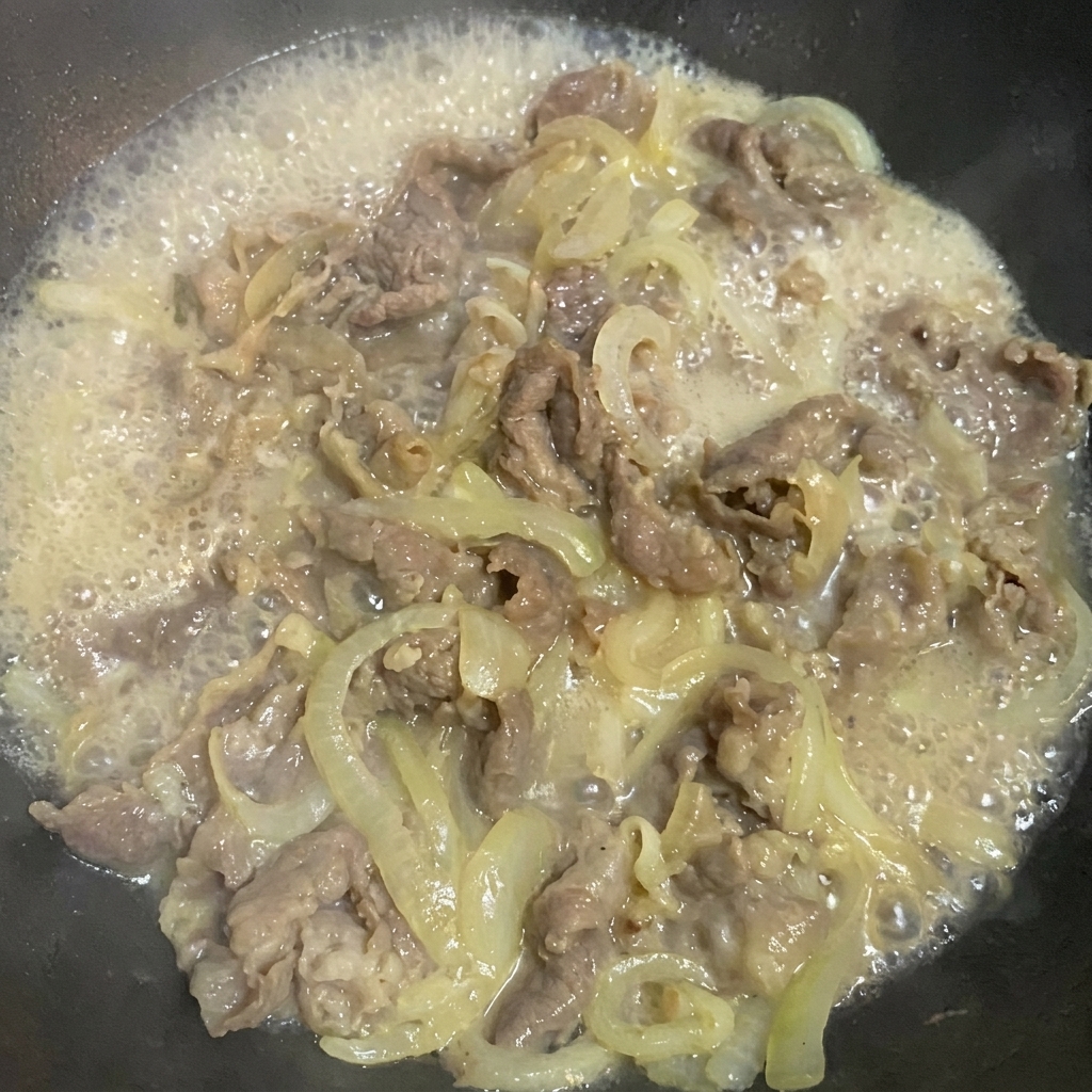 Seasoning the beef and onion mixture with soy sauce, sugar, and salt.