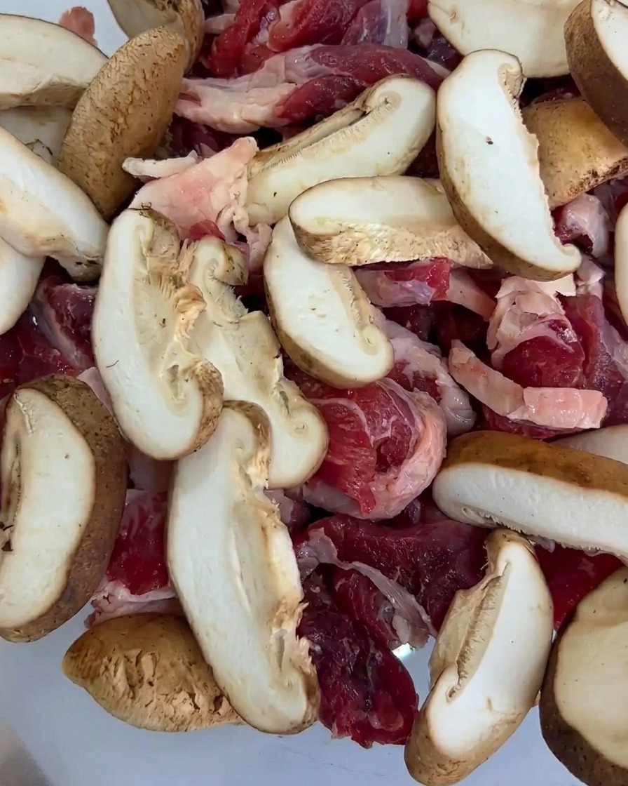 Fresh baby corn pieces added to the tray, mixed with the beef and mushroom slices.