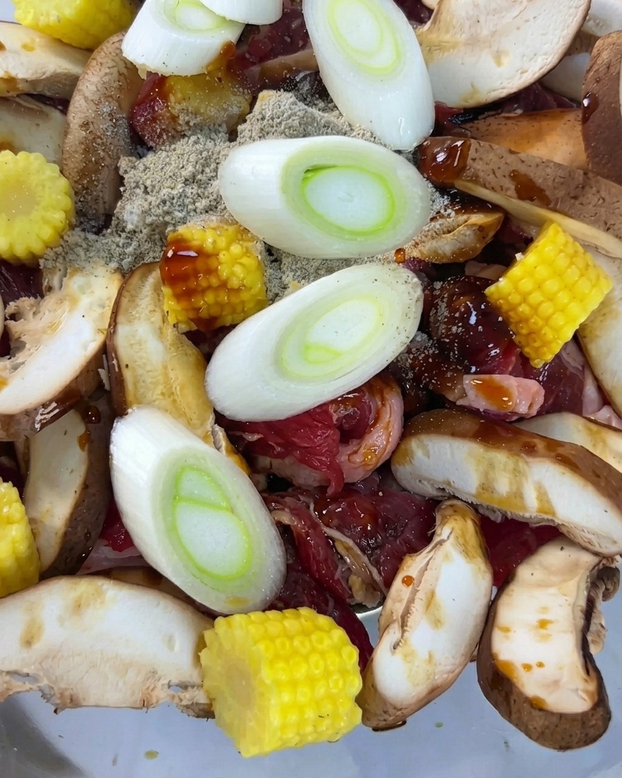 Slices of fresh green onions resting on top of the seasoned beef and vegetable mixture.