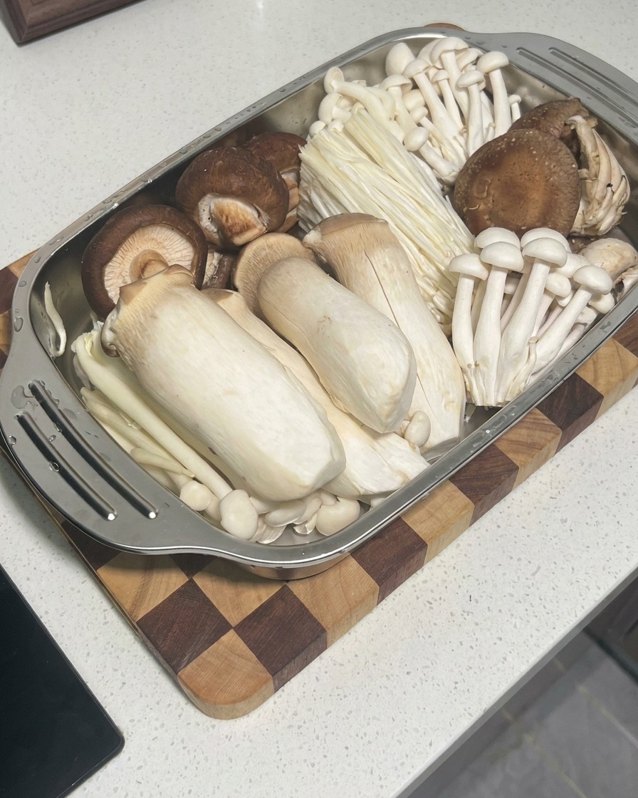Raw shrimp paste being squeezed from a piping bag into the center of shiitake mushroom caps.