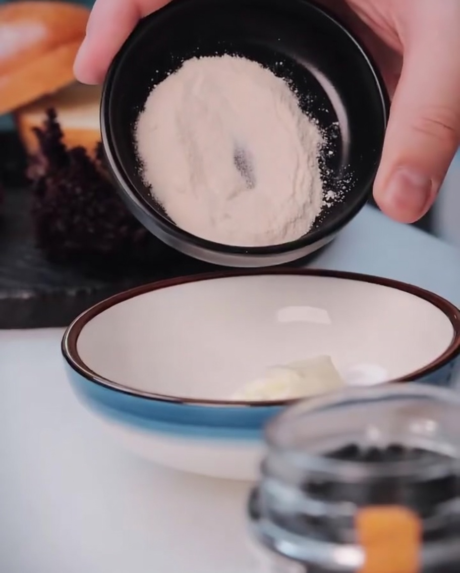 Garlic powder being added to the bowl of mayonnaise.