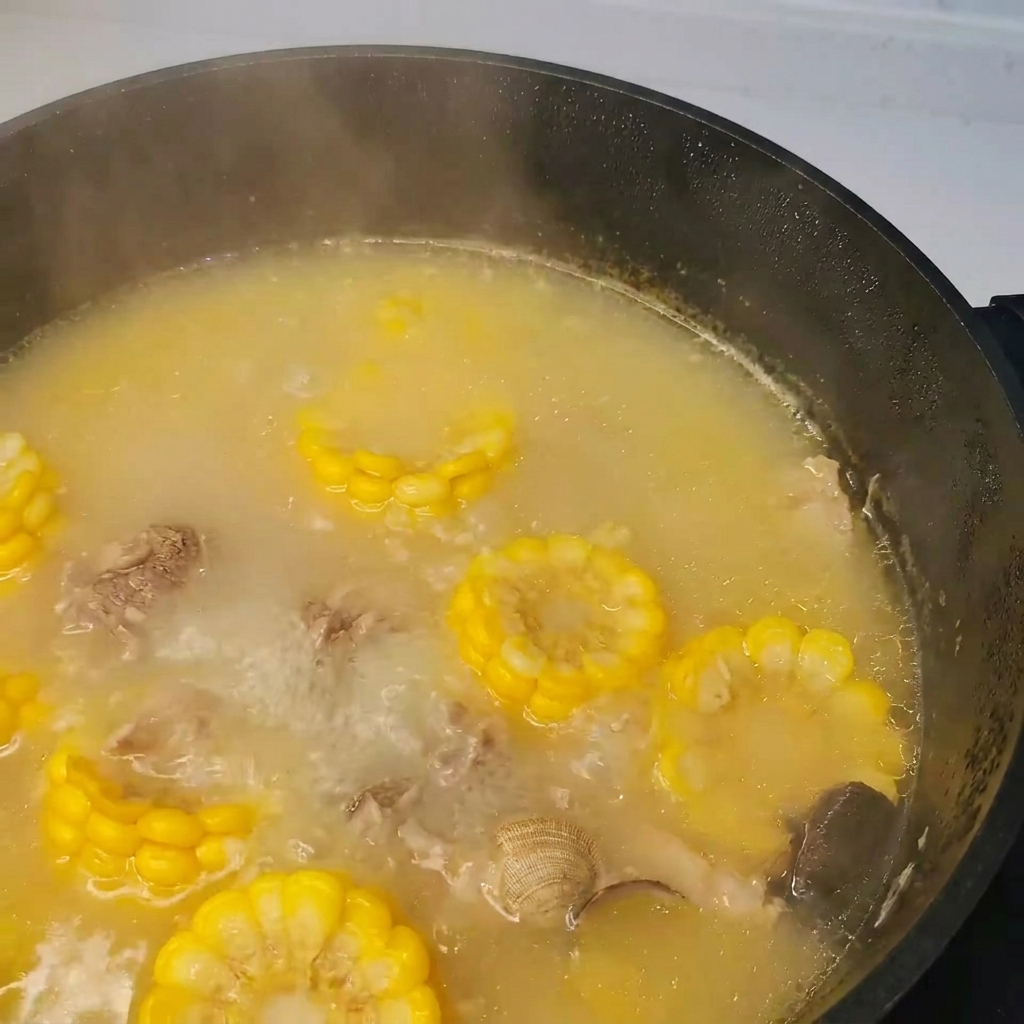 Seaweed (kelp) being added to the pot of boiling pork, clam, and vegetable soup.