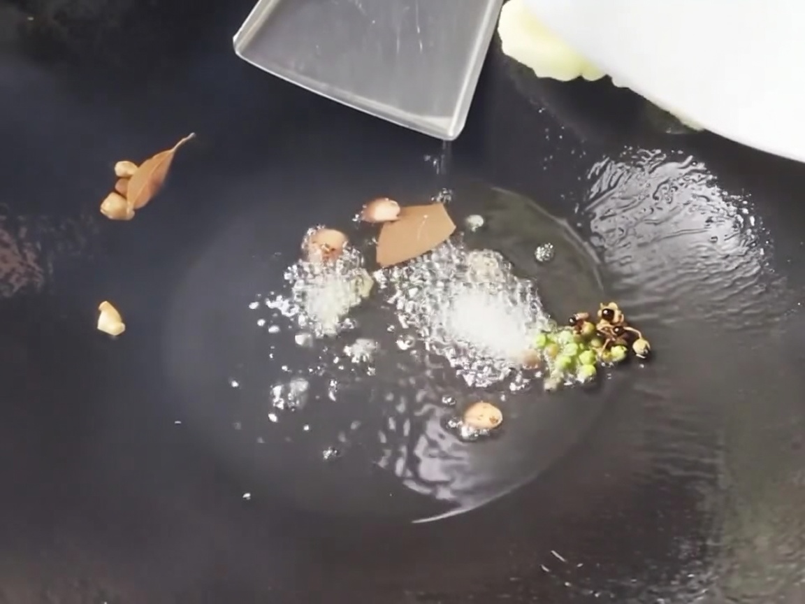 Freshly sliced bamboo shoots and corn segments being stir-fried in a hot wok with aromatics.