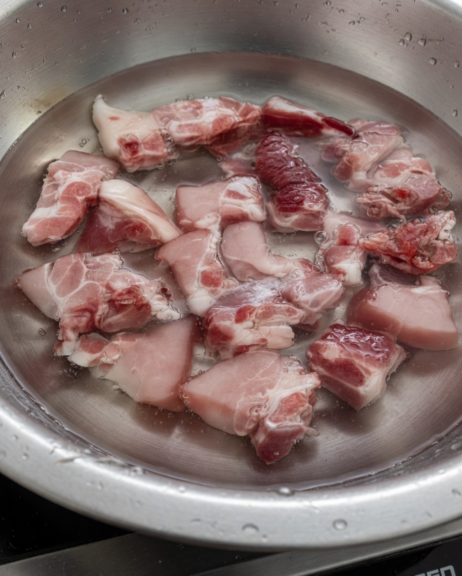 Pork rib pieces boiling in water to remove impurities.