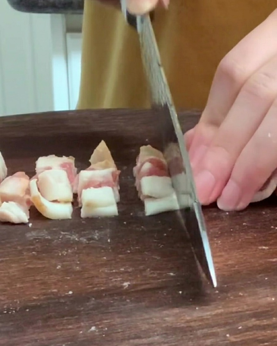 Small cubes of potato being dropped into a pot of boiling water.