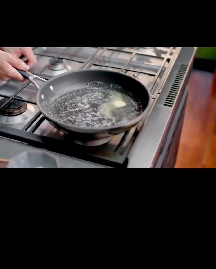 Melted butter and flour being whisked together in a pan to create a smooth, light roux.