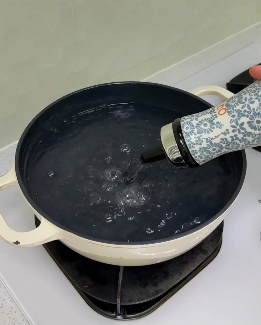 Adding salt and oil to a pot of water on the stove.
