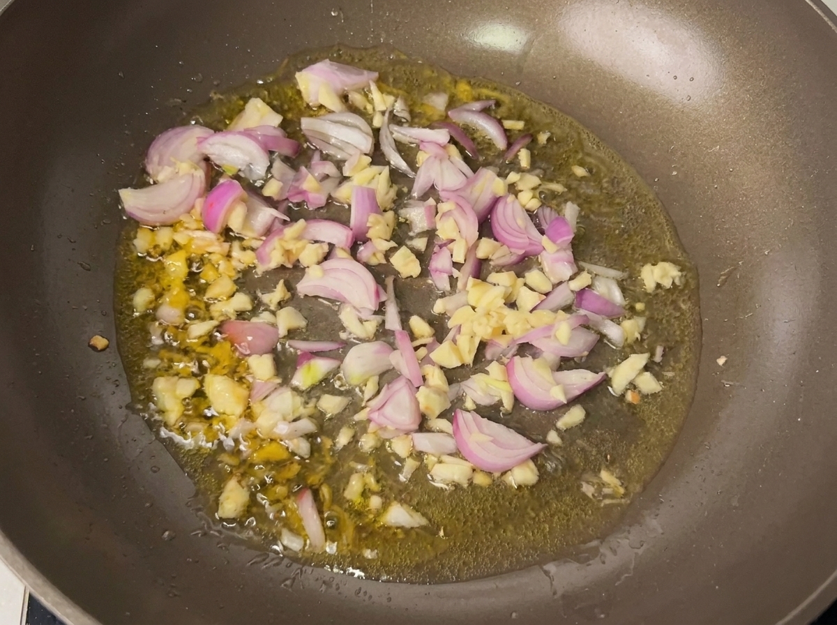Aromatic garlic and shallots frying in hot oil in a pan.