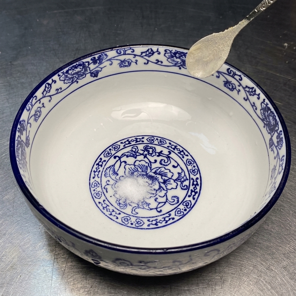 Salt, MSG, and white pepper sitting at the bottom of a decorative ceramic bowl.