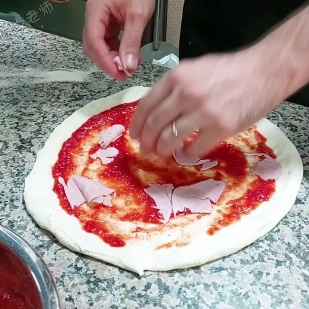 Thin slices of ham being placed on top of the tomato sauce-covered pizza base.