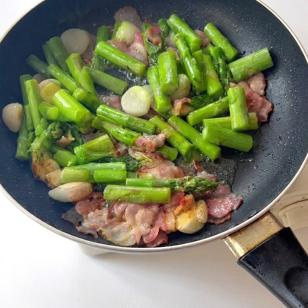 Minced meat browning in a pot with sesame oil, being stirred with chopsticks.