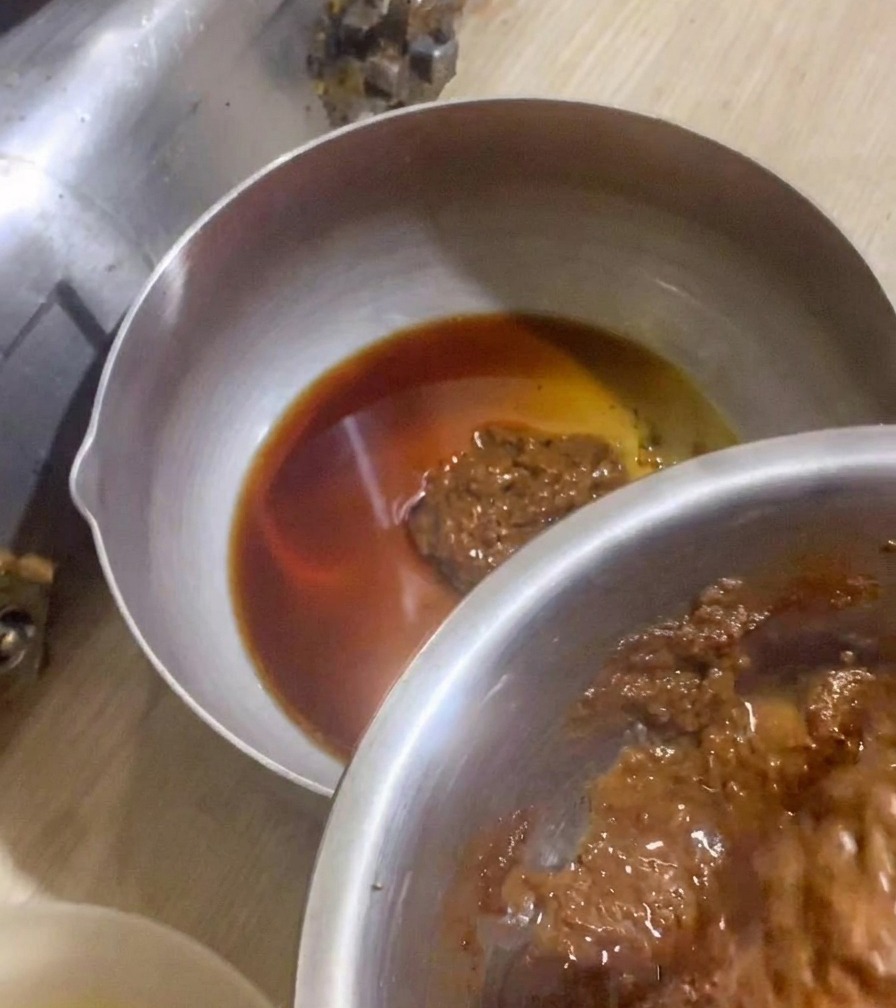 Various sauce components being blended together in a small saucepan.