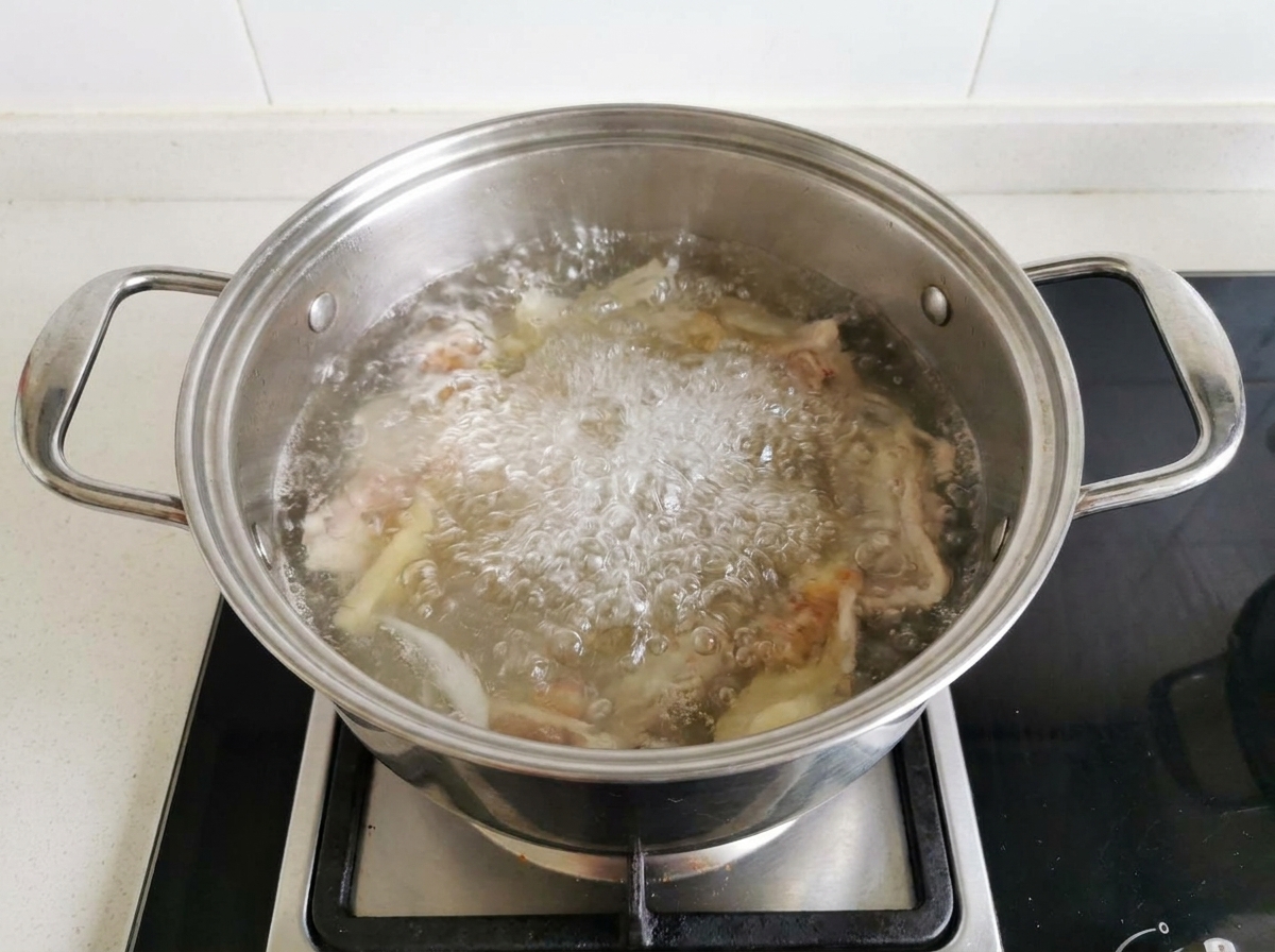 Fish sauce being squeezed from a plastic bottle into a pot of boiling soup.