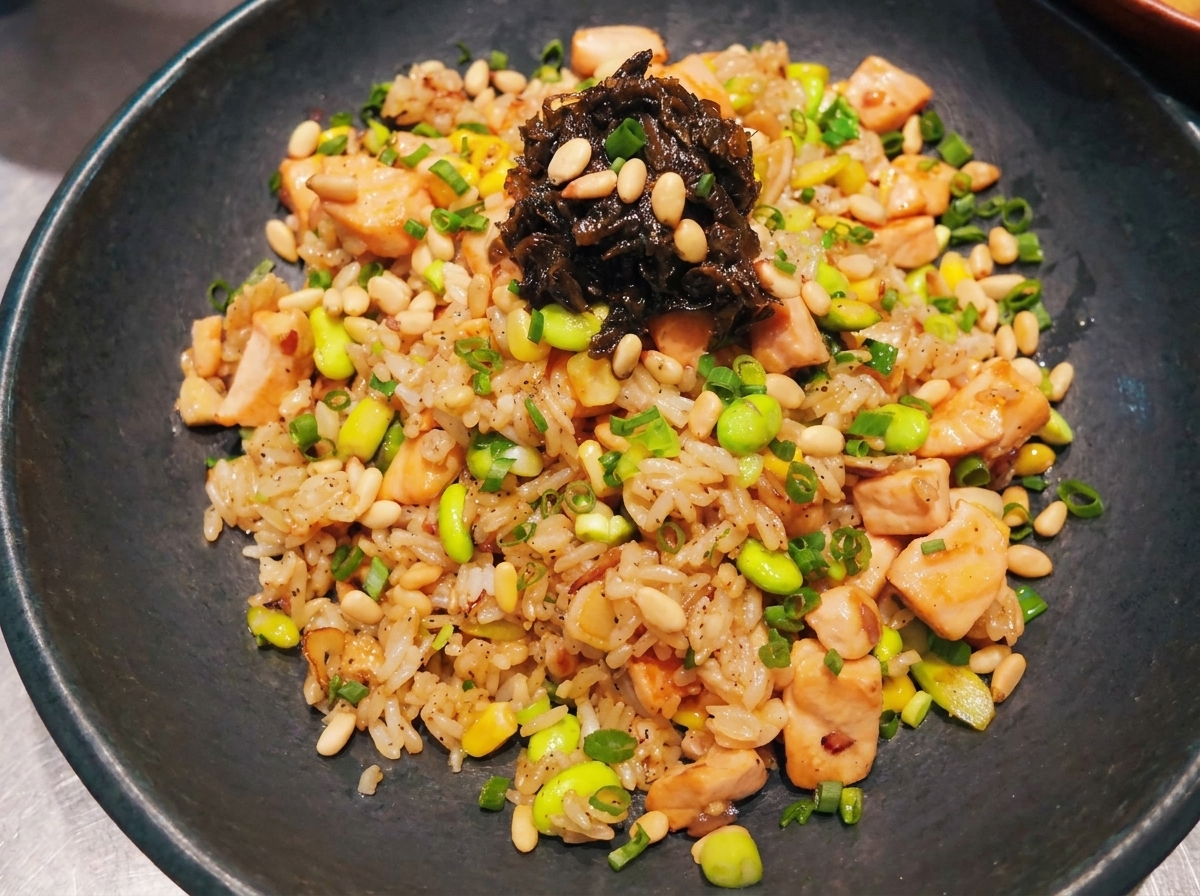 Cubed salmon pieces being stir-fried in a hot pan.