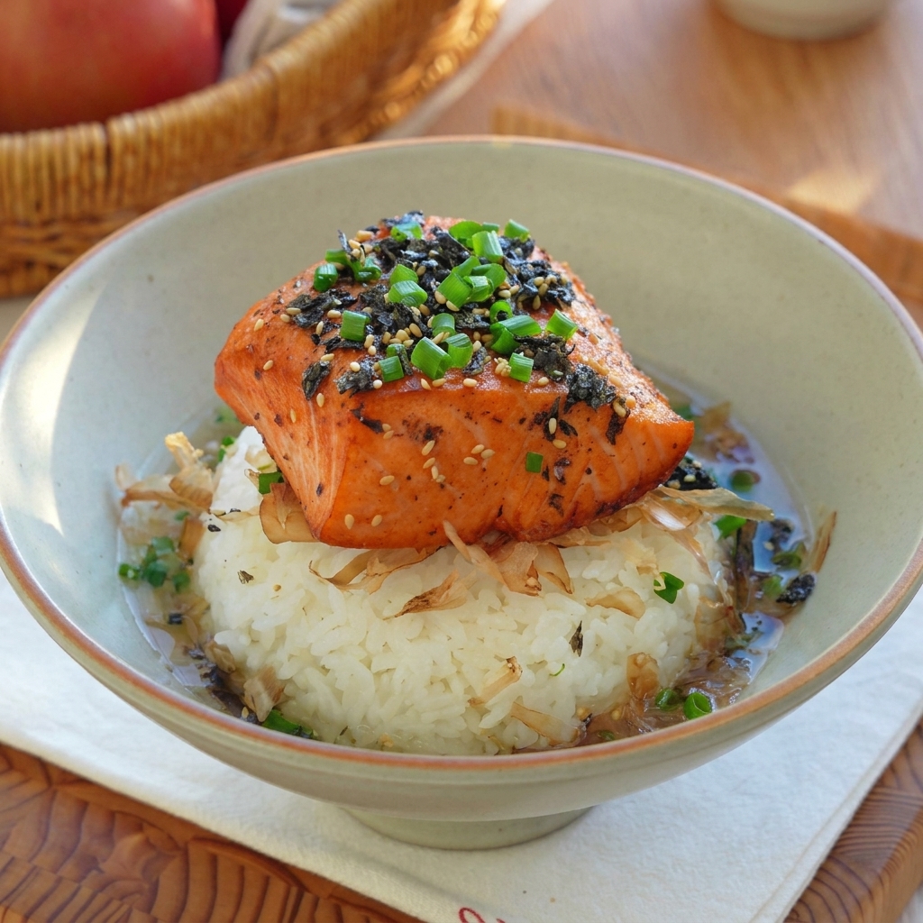 The golden genmaicha tea broth being poured into the bowl, creating a flavorful liquid base for the salmon and rice.