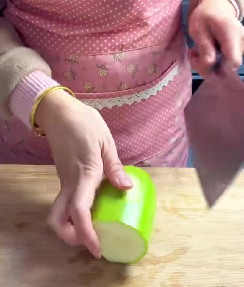 Chayote pieces cut into uniform, thick cubes on a wooden cutting board.