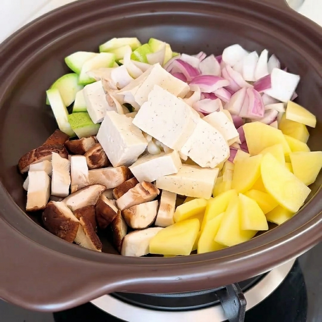 A hand pouring water from a measuring cup into the pot containing the vegetables and seasonings.