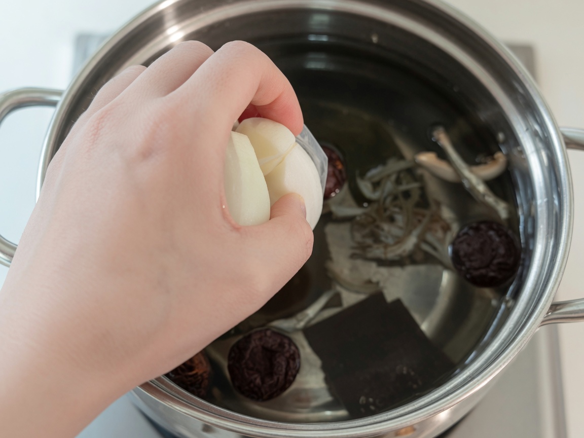 Boiling water in a pot containing kelp, anchovies, shiitake mushrooms, onion, and radish.