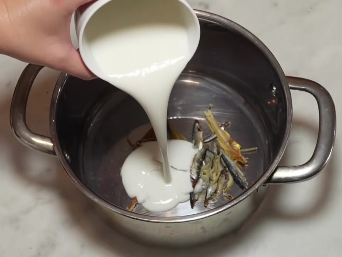 Dry squares of kombu kelp sitting inside the pot with the anchovies.