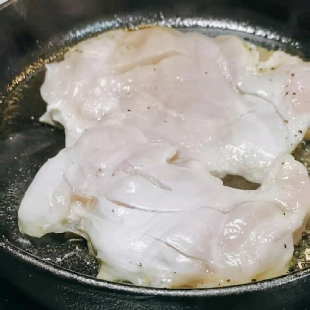 Teriyaki sauce and white wine being poured into the pan over the cooking chicken.