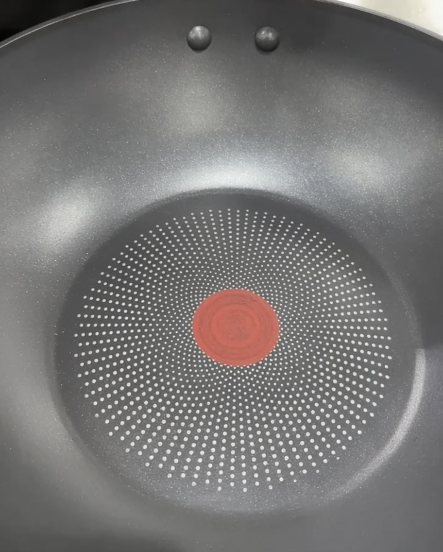 Two halves of a soft, golden Brioche potato bun being toasted in a dry frying pan.