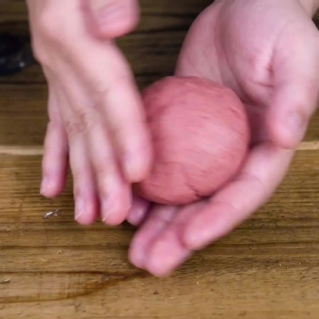 Hands shaping the meat mixture into a thick, round patty.