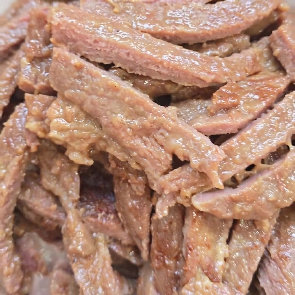Beef strips searing in a pan until browned.